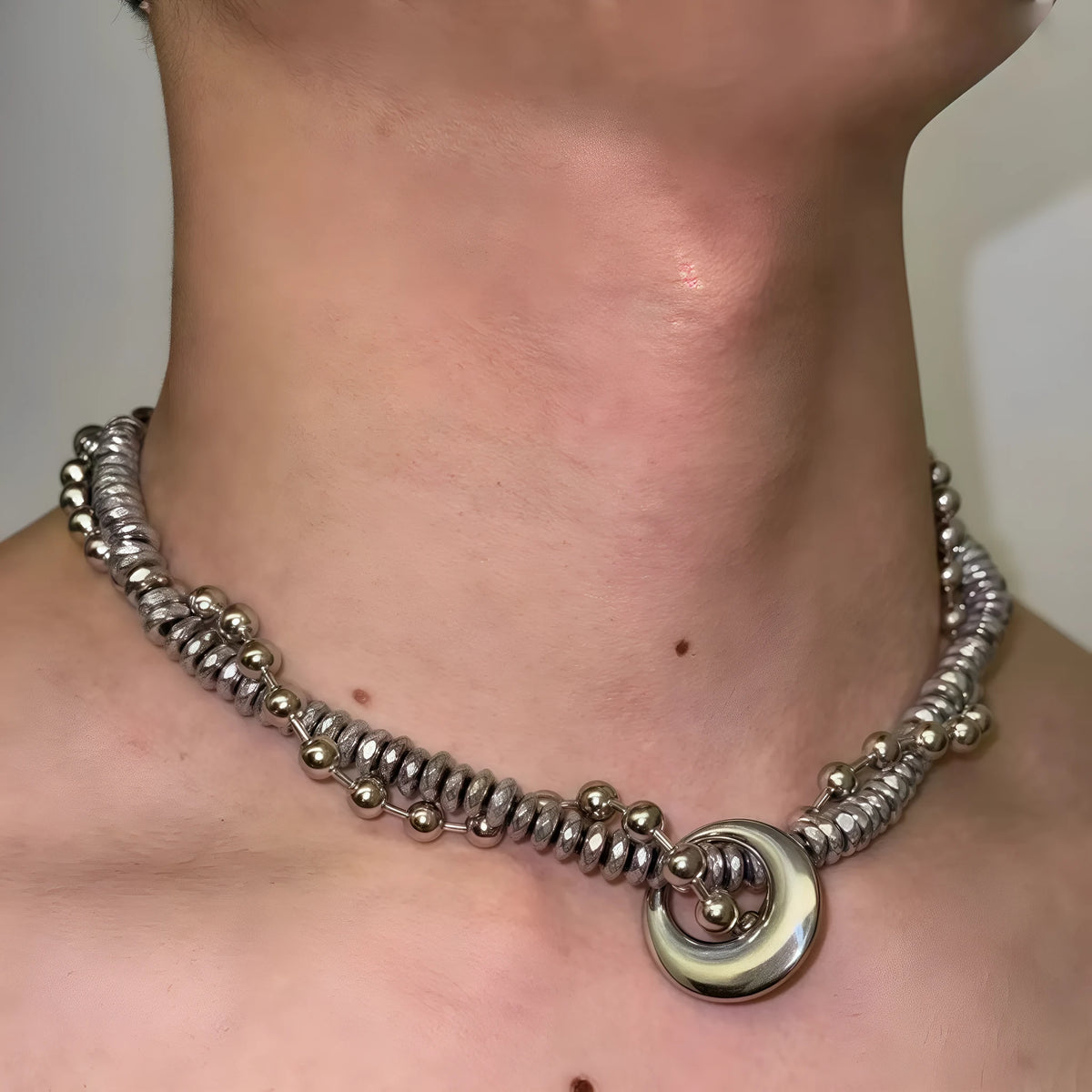 Silvery hand-woven titanium steel hip hop necklace with winding heavy industry chain texture on white background