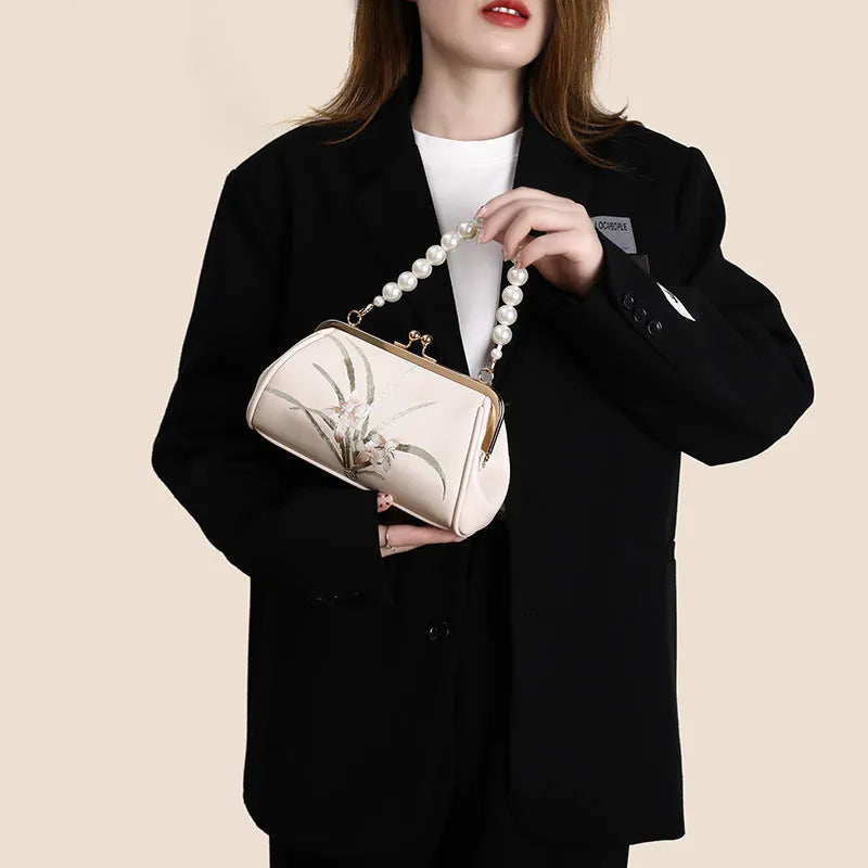 Beige women's shoulder bag with embroidery detail and shell-shaped design in soft PU leather