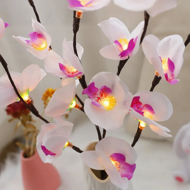 Pink silk orchid LED branch light, 65cm long, with glowing warm white LEDs on fabric petals and plastic stem.