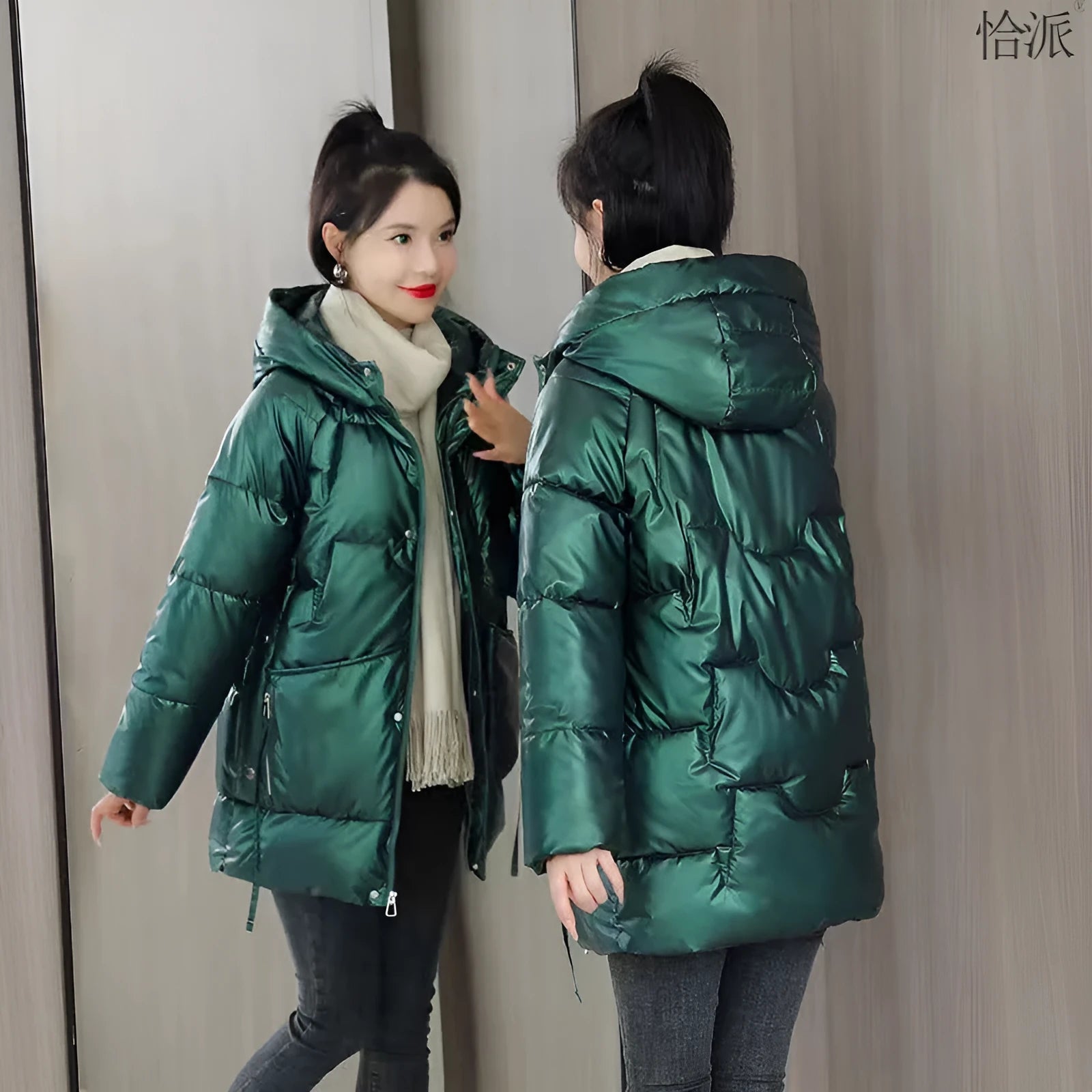 Women's loose-fit green hooded winter jacket with long sleeves on a hanger.
