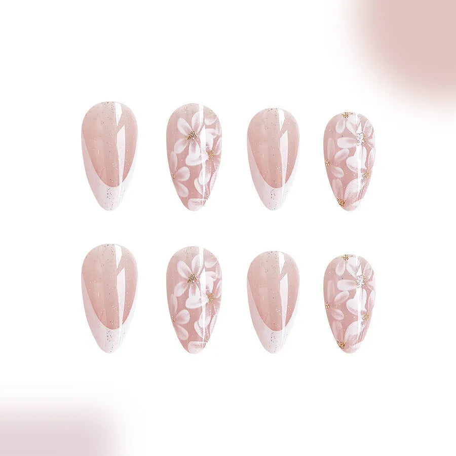 Short almond-shaped plastic false nails with glossy white French tips and pink glitter powder flower design.