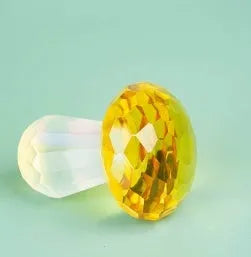 Small decorative crystal mushroom ornament in modern geometric style on a plain background.