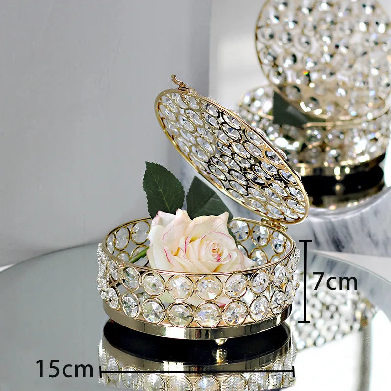 Transparent crystal glass jewelry storage box with a French gold-coloured metal frame on a table.
