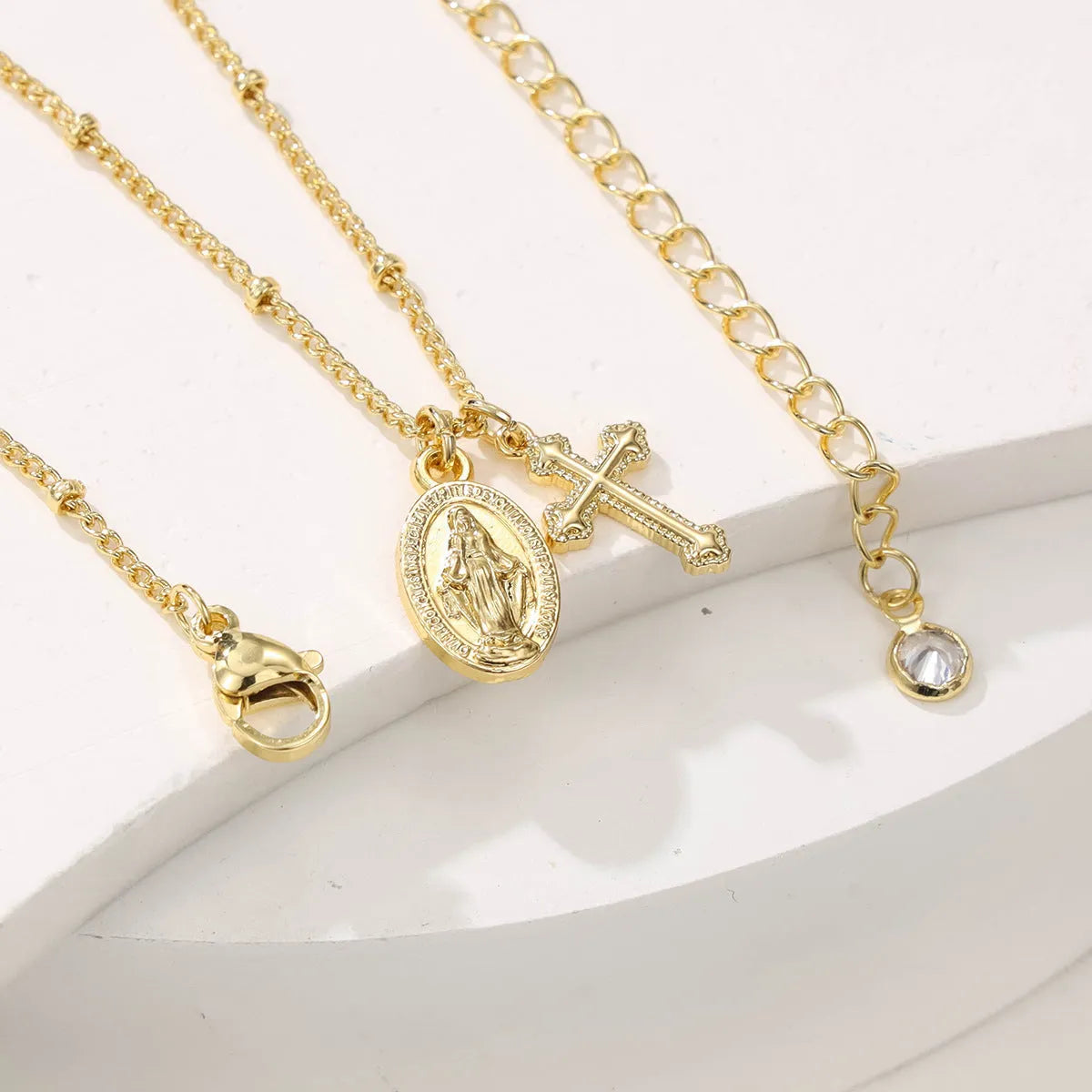 Geometric Virgin Mary cross pendant necklace in gold on a 45cm chain with lobster clasp.