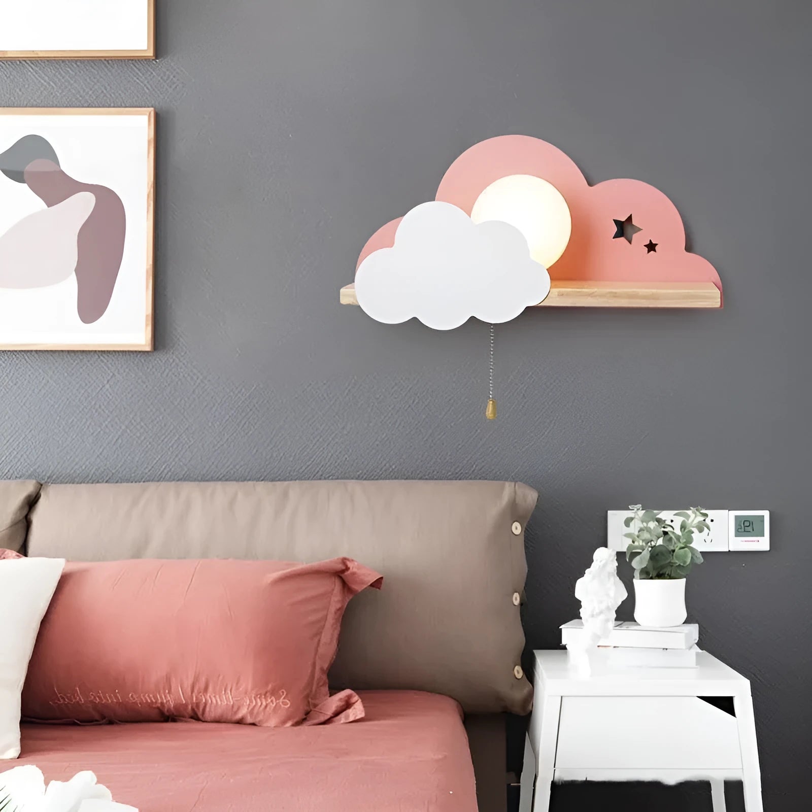 Glass cloud-shaped decorative wall lamp in grey, mounted beside a bed.