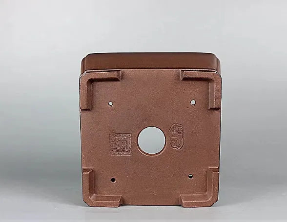 Handmade brown antique-style purple clay square flower pot on a surface.