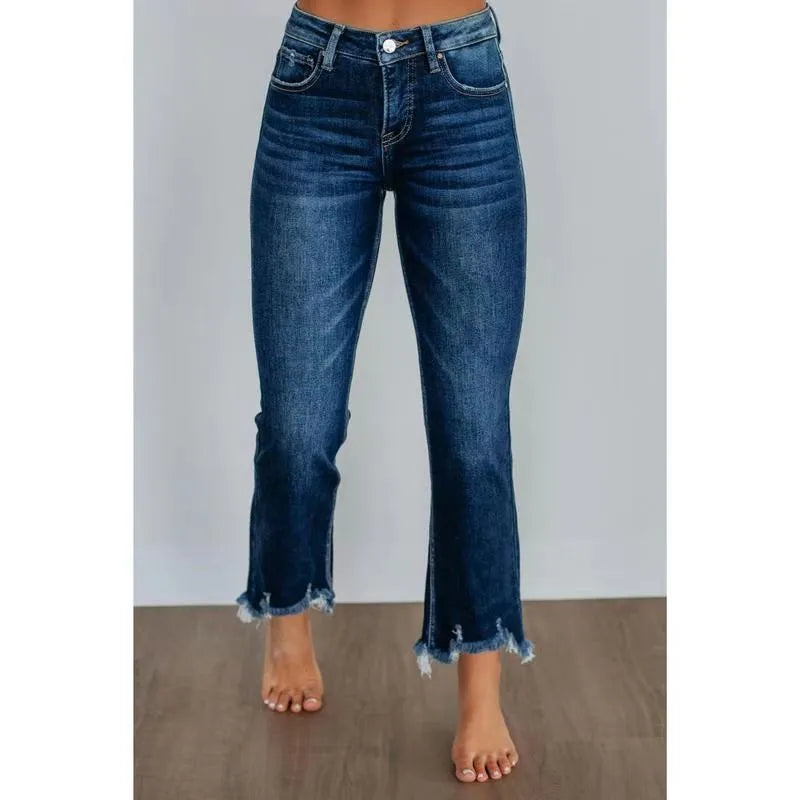 Women's solid colour denim jeans with hand-worn distressing in dark blue, laid flat.