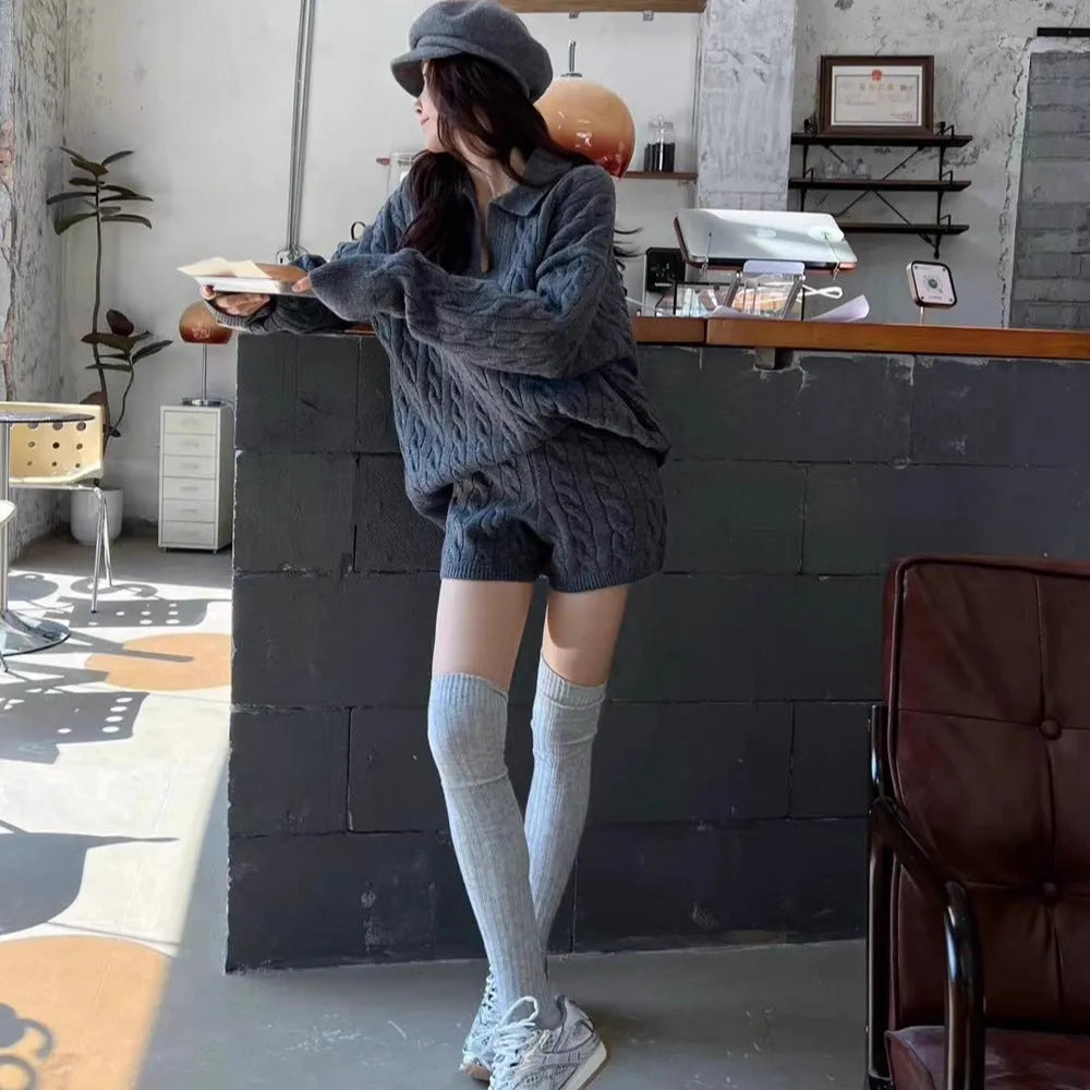 Cream-white knitted set with geometric pattern sweater and matching elastic waist shorts laid flat.