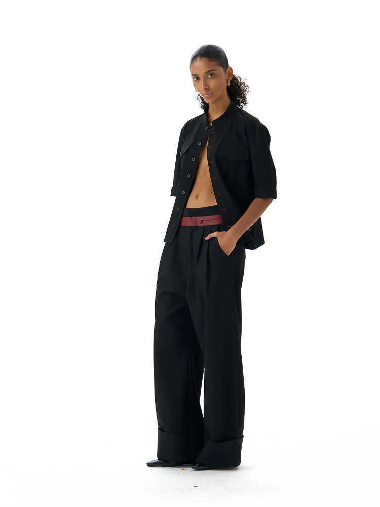Handmade black loose fit half sleeve shirt with a shirt collar on a hanger.