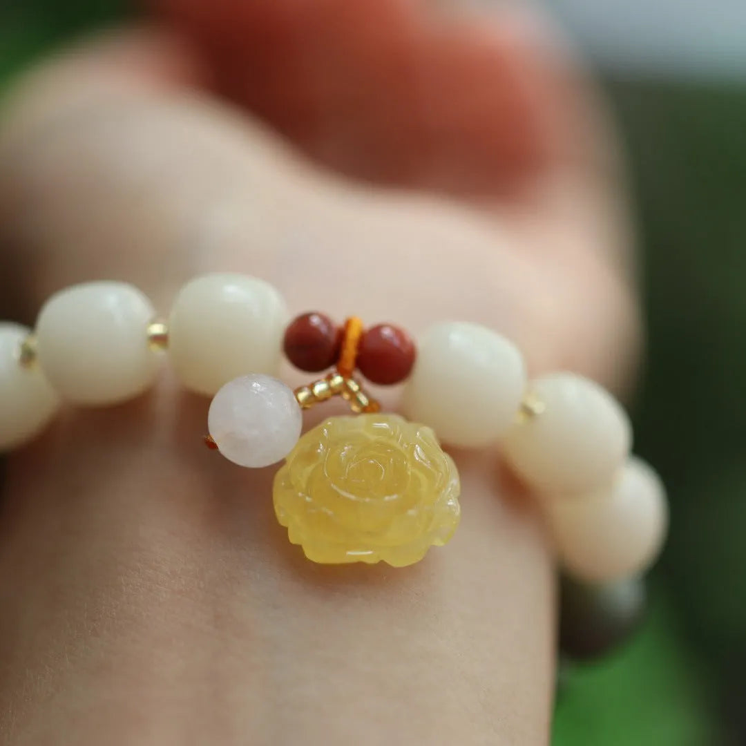 Woven bodhi bracelet with gradient white jade beads and natural beeswax lotus pendant on wrist
