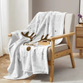 Deer antler pattern Christmas limited edition white flannel velvet blanket on a sofa