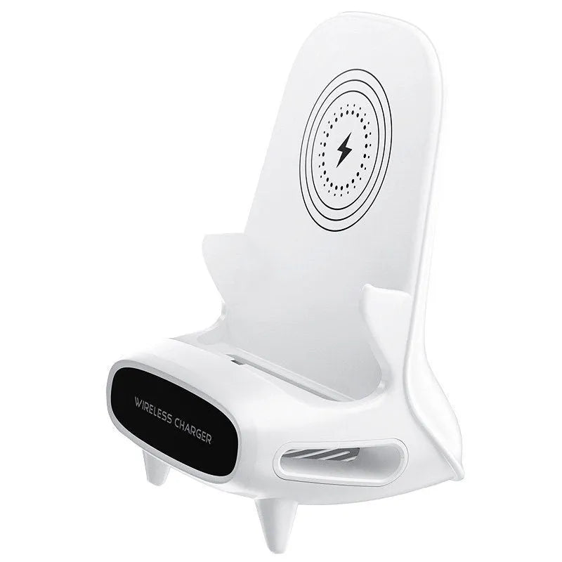 White mini chair shaped wireless charging stand holding a mobile phone on a desk.