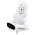 White mini chair shaped wireless charging stand holding a mobile phone on a desk.