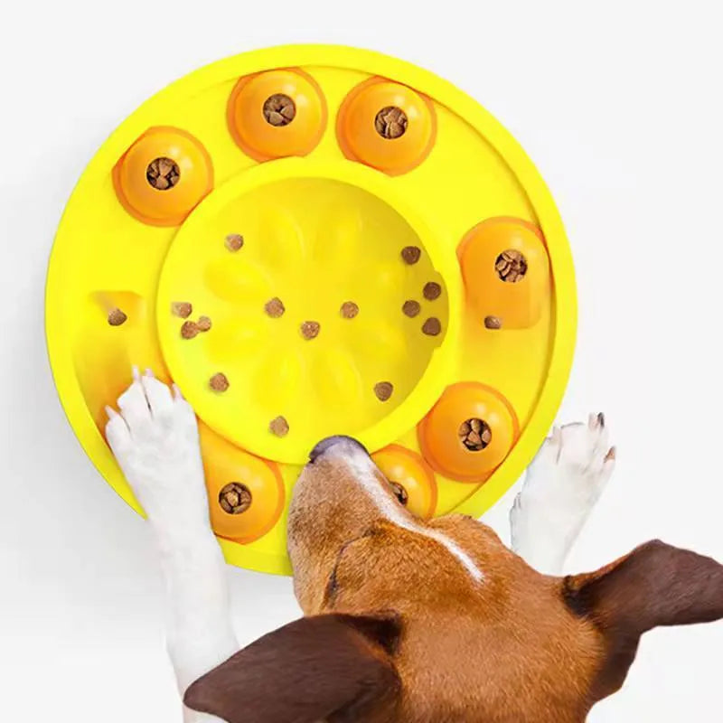 Square green dog puzzle toy with a central feeding well and a rotating turntable lid on a hard floor.
