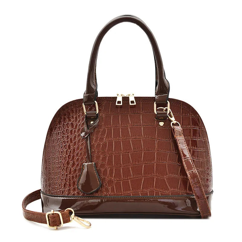 Shiny black structured shell shape crossbody shoulder bag showing large capacity and interior lining.