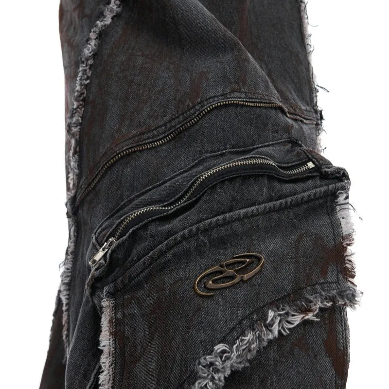 Black raw edge splash-dye distressed denim coat with padded shoulders and matching pants laid flat.