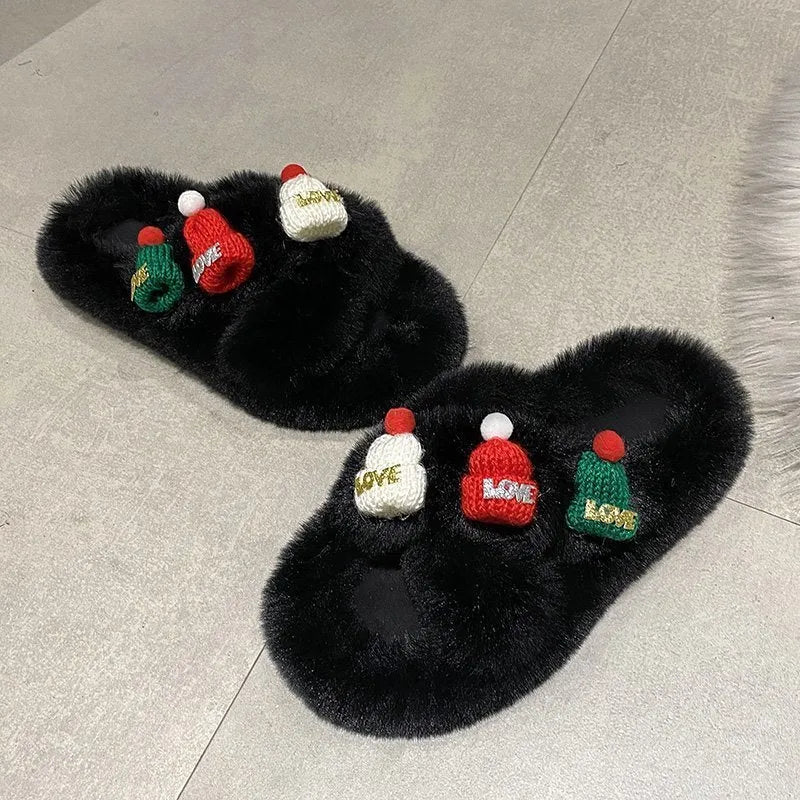 Women's faux plush slippers with a Christmas hat decoration design in black, shown on a foot.