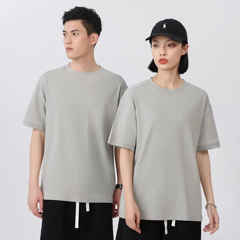 Men's loose-fit short-sleeved cotton pique T-shirt on a hanger, shown in a solid colour.