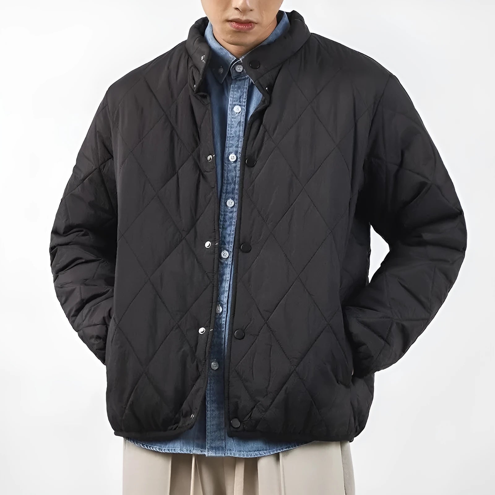 Men's black diamond lattice quilted winter jacket showing lengthened silhouette and loose fit