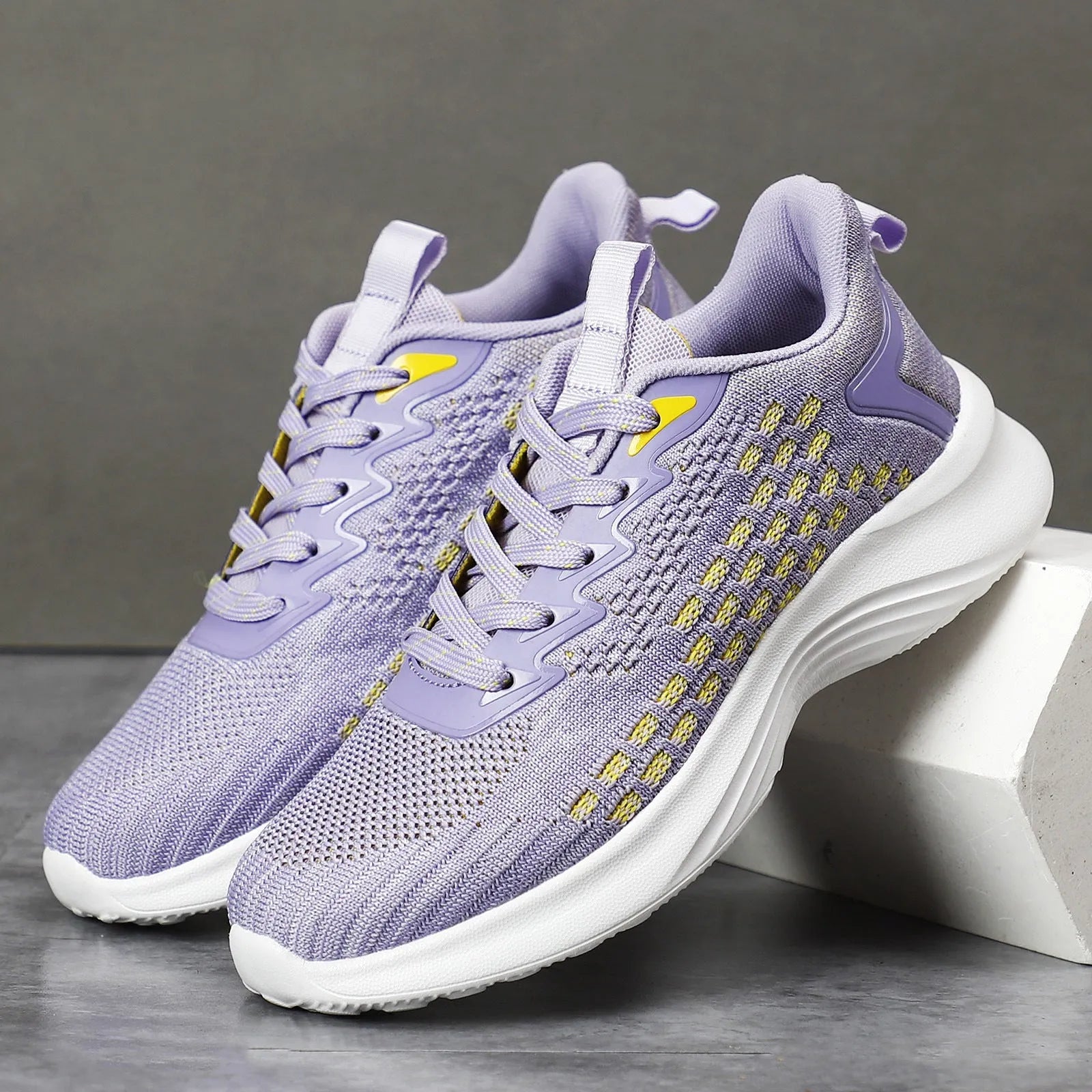 Women's Lavender Purple Flyknit running shoes with mesh detailing and a striped pattern on a white background.