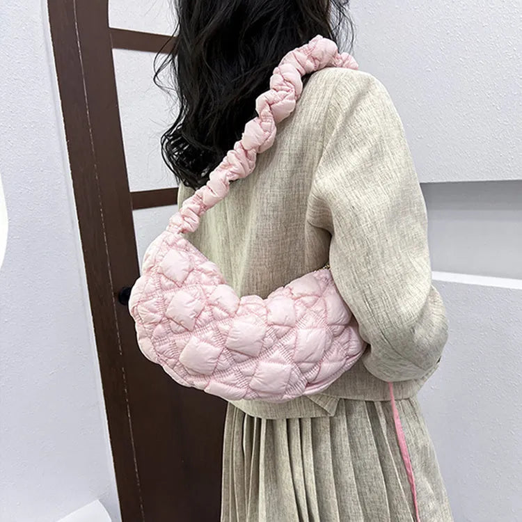 Women's light beige nylon cloud underarm messenger bag with a long adjustable shoulder strap.