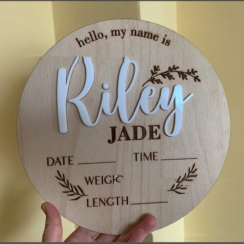 Square wooden newborn name label plaque for baby birth information on a natural plywood background.