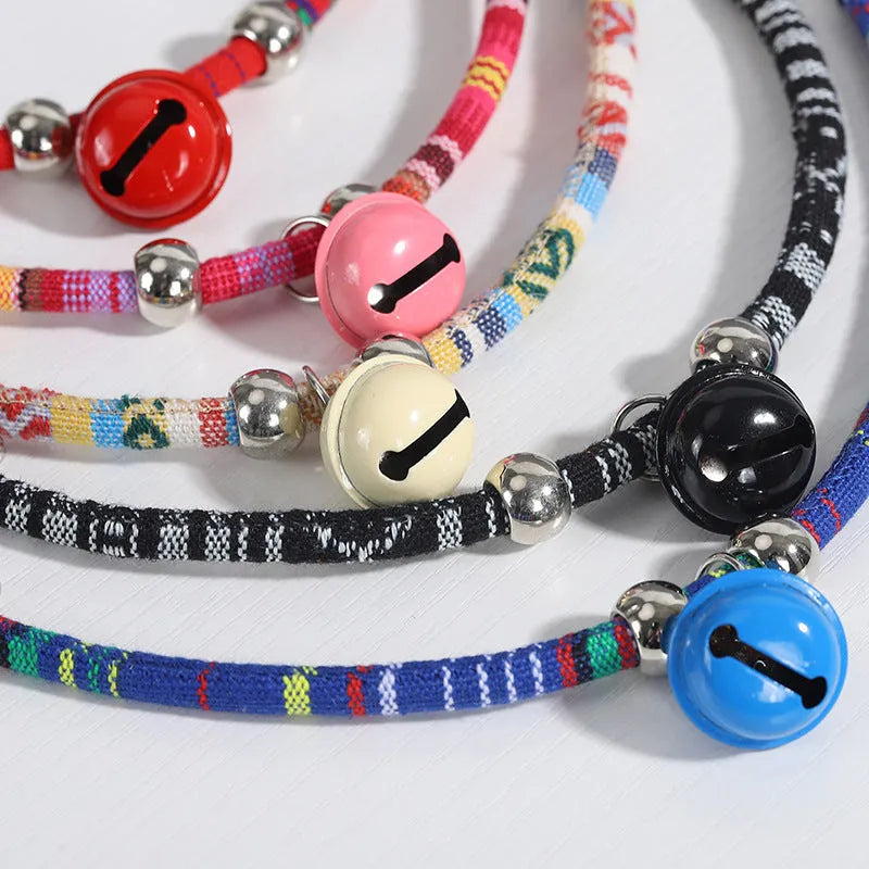 Coloured ethnic style pet collar with a metal bell on a cat or small dog