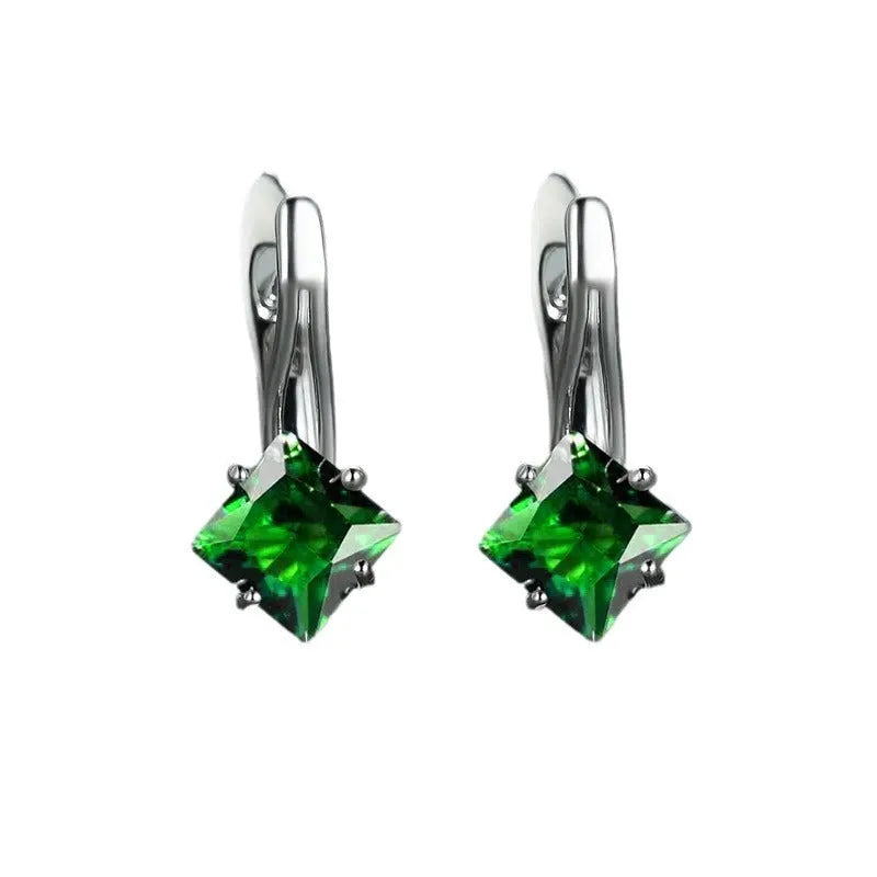 Women's copper earrings with diamond design and inlaid blue zircon stones on a white background.