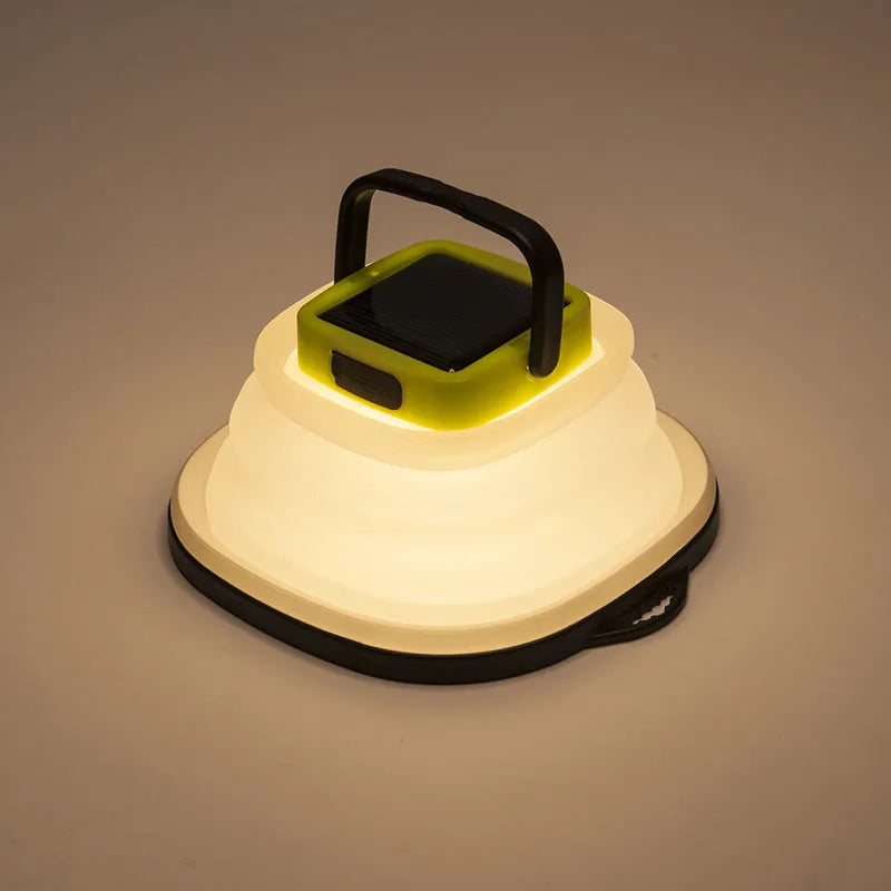 Green telescopic LED camping light folded and extended on a table with suction cup