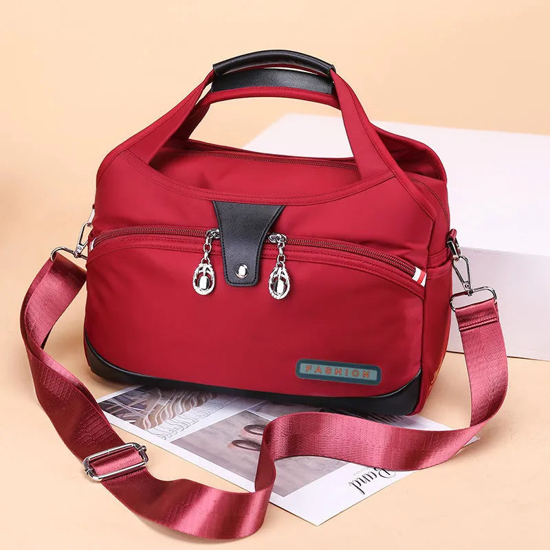 Women's crossbody bag in Oxford cloth with zippered closure and adjustable shoulder strap, 29cm long, available in multiple colours