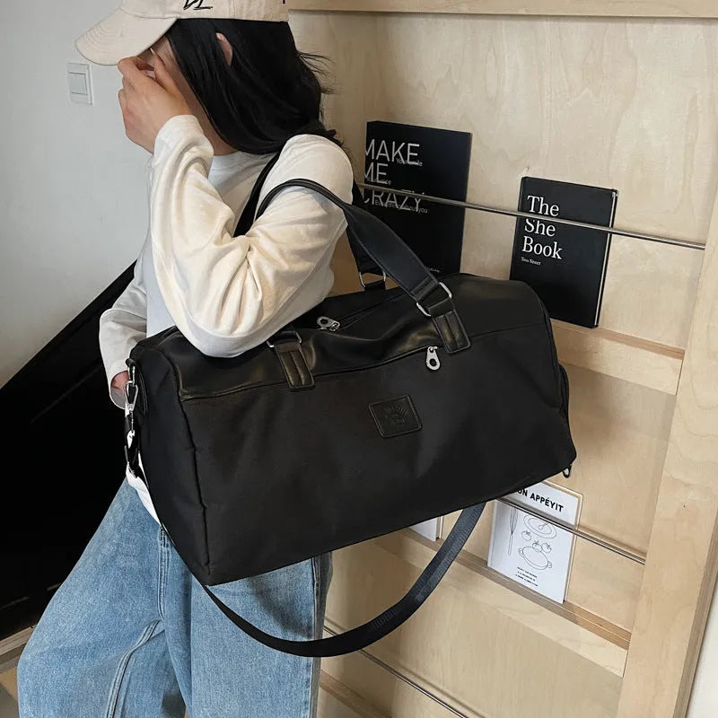 Black Oxford cloth large capacity messenger bag with a top handle and adjustable shoulder strap.