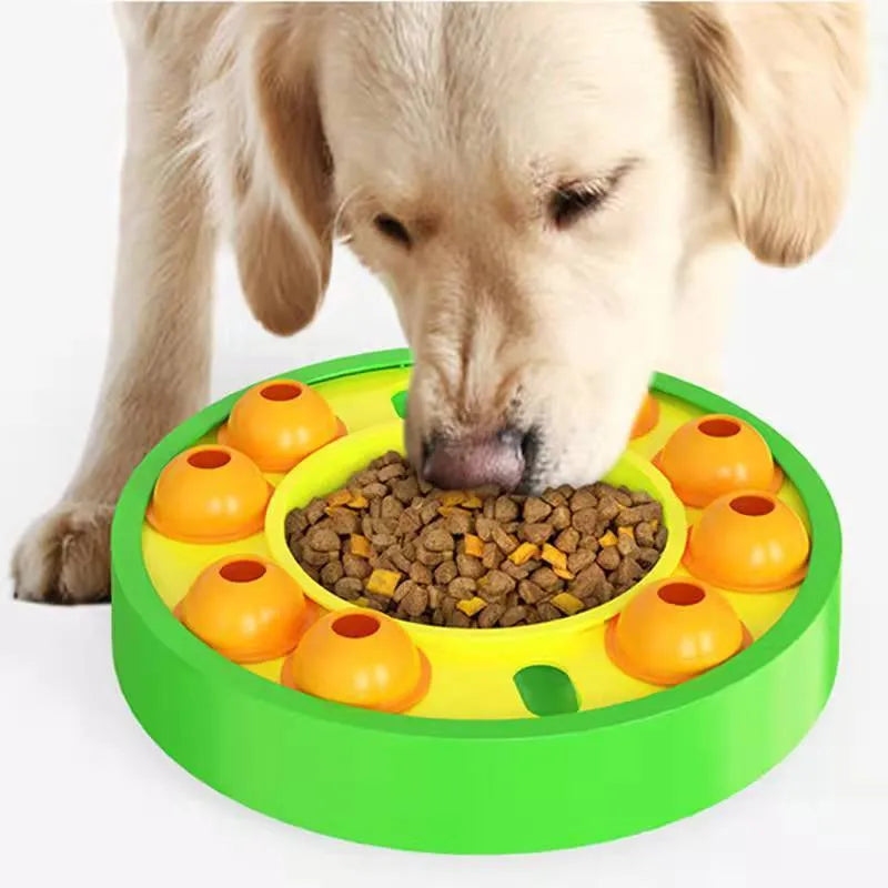 Square green dog puzzle toy with a central feeding well and a rotating turntable lid on a hard floor.