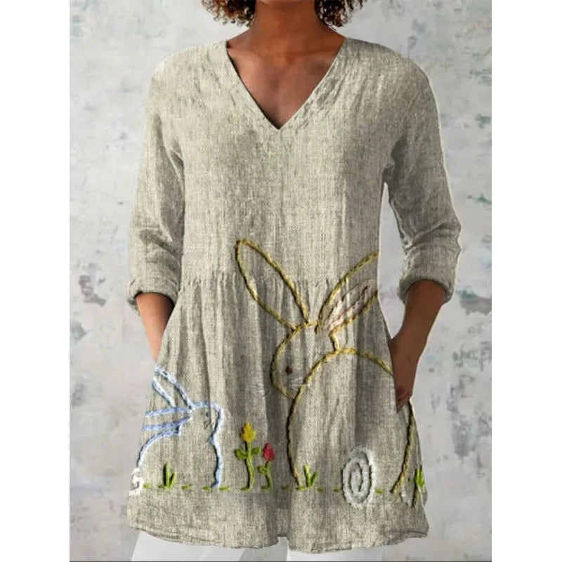 Printed women's loose wave dress with wide waist and three-quarter sleeves on a hanger.