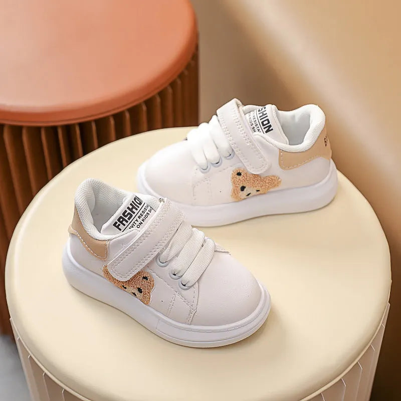 Children's black sports shoes with a cartoon bear design on the artificial leather upper and a rubber sole.