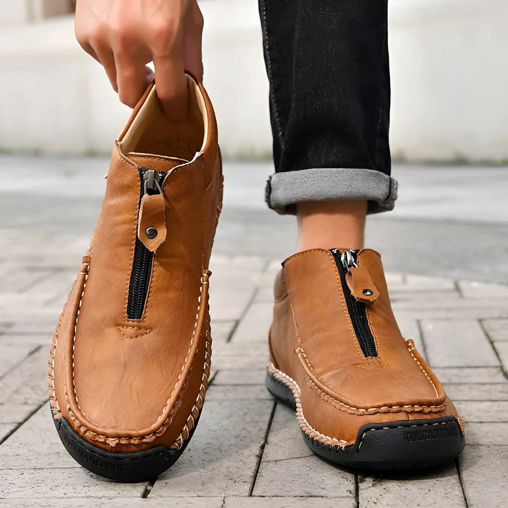 Men's black slip-on leather loafers with round toe and sewn sole on a rubber outsole.