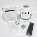 Compact white cube-shaped USB galaxy projection lamp with remote control on a table