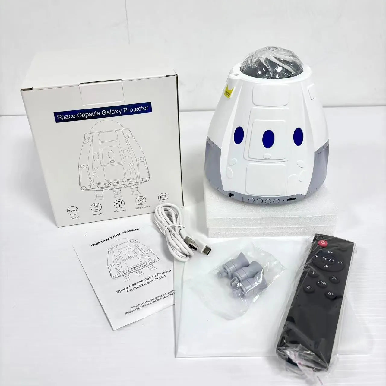 Compact white cube-shaped USB galaxy projection lamp with remote control on a table