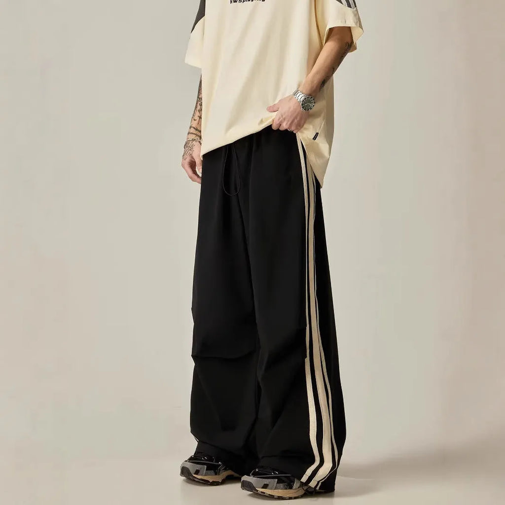 Black wide-leg men's climbing trousers with a high waist on a neutral background.