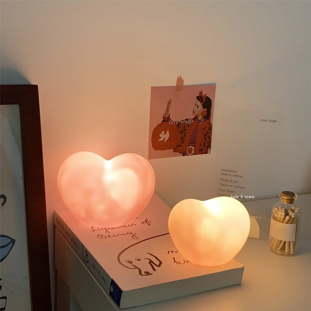 White and pink vinyl atmosphere lamps in small and large sizes with warm glowing light.