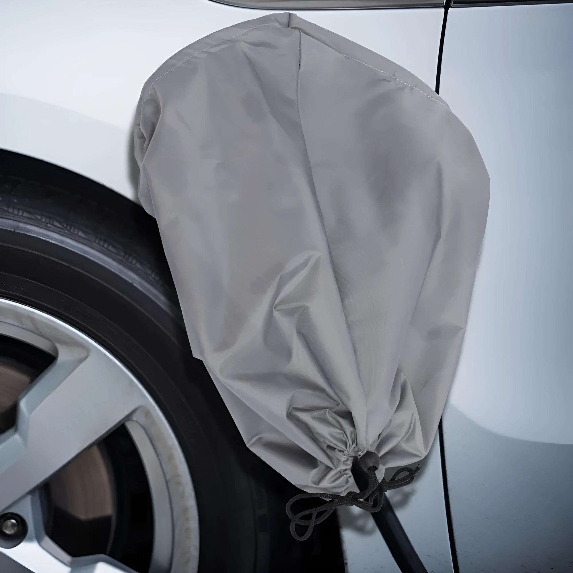 Grey waterproof drawstring cover for an outdoor electric vehicle charging unit.