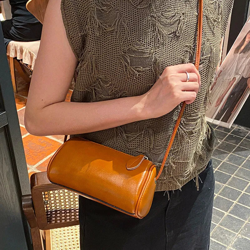 Genuine first layer cowhide crossbody bag in cylinder shape with sewing line details, available in six colours
