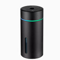 Black aluminium portable car humidifier and essential oil diffuser with USB cable on a desk.