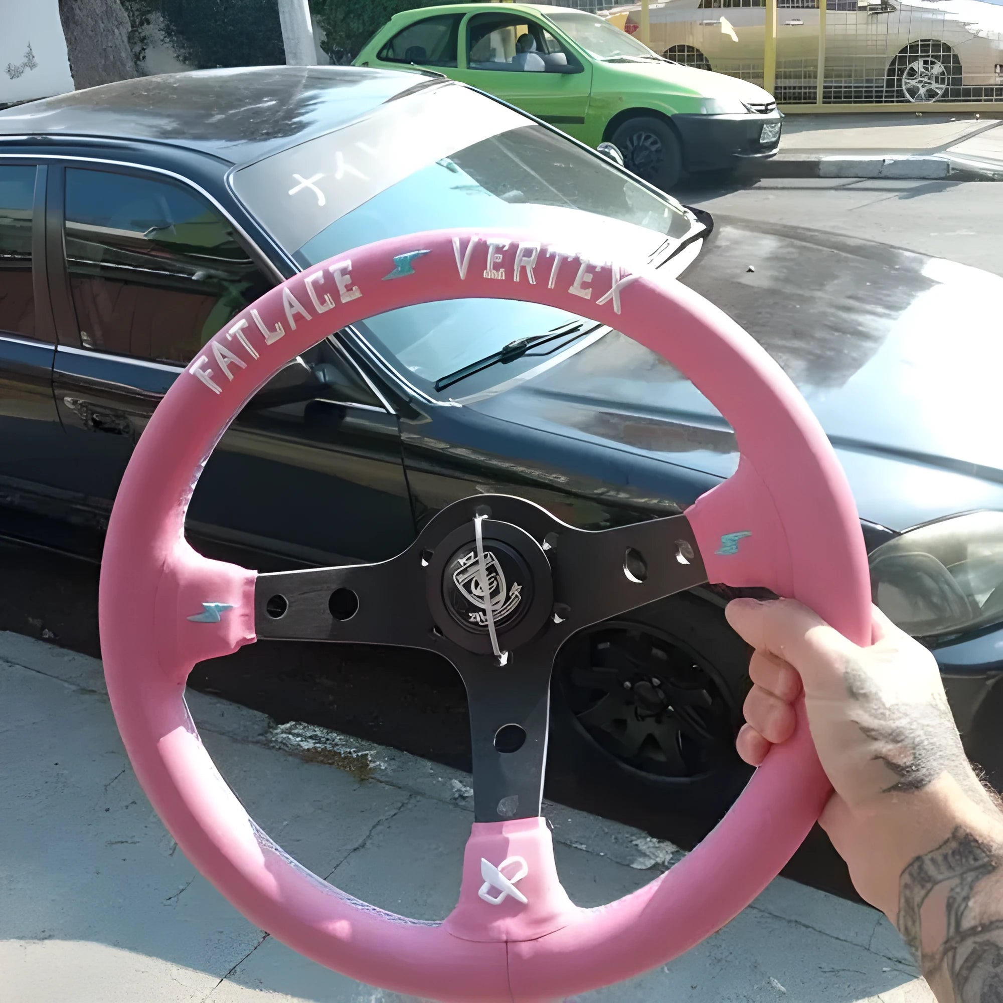 Pink leather steering wheel cover with embroidery, showing aluminium bracket