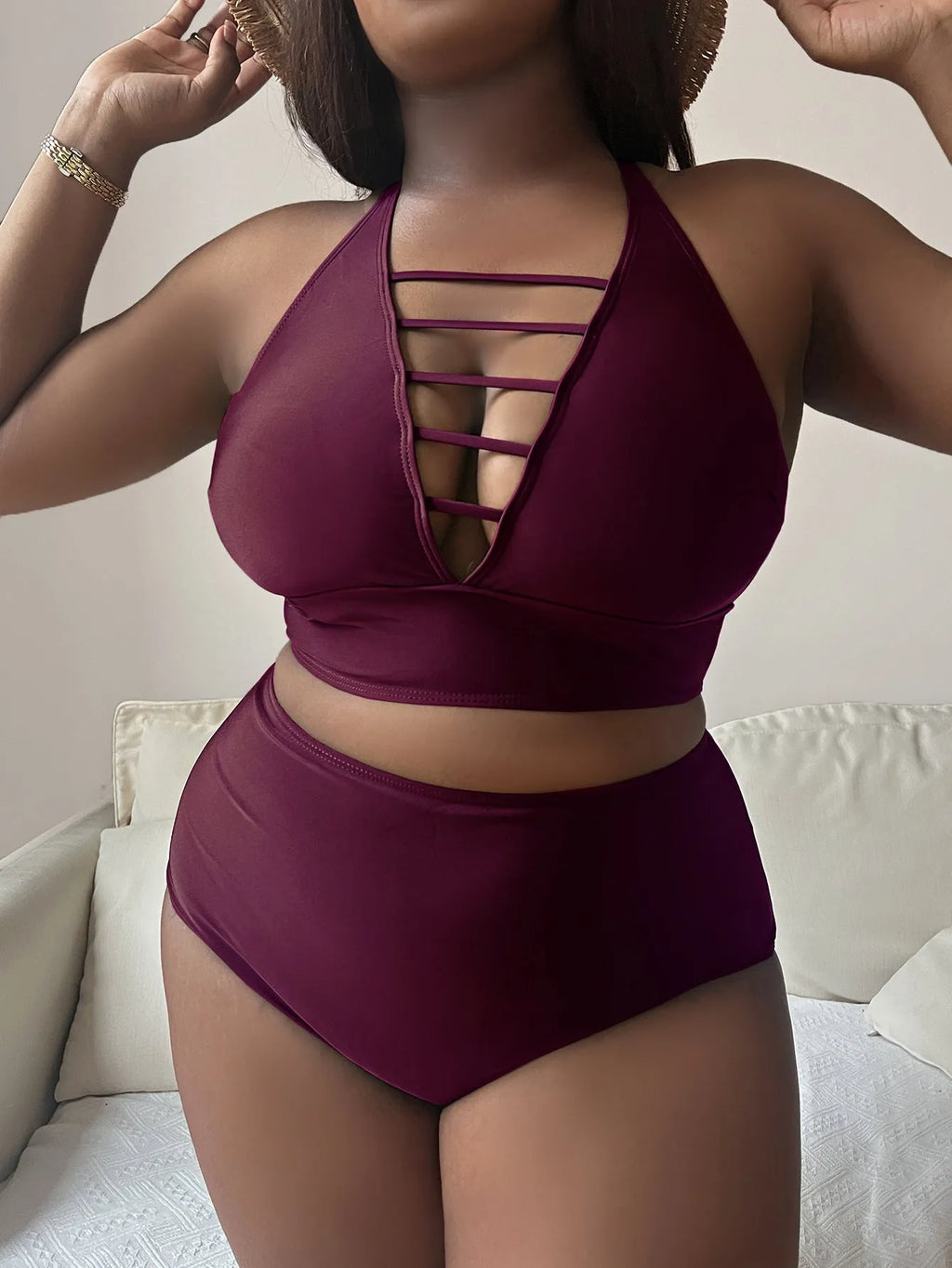 Plus size woman modelling a black halter bikini with adjustable cross straps and high-waisted briefs.