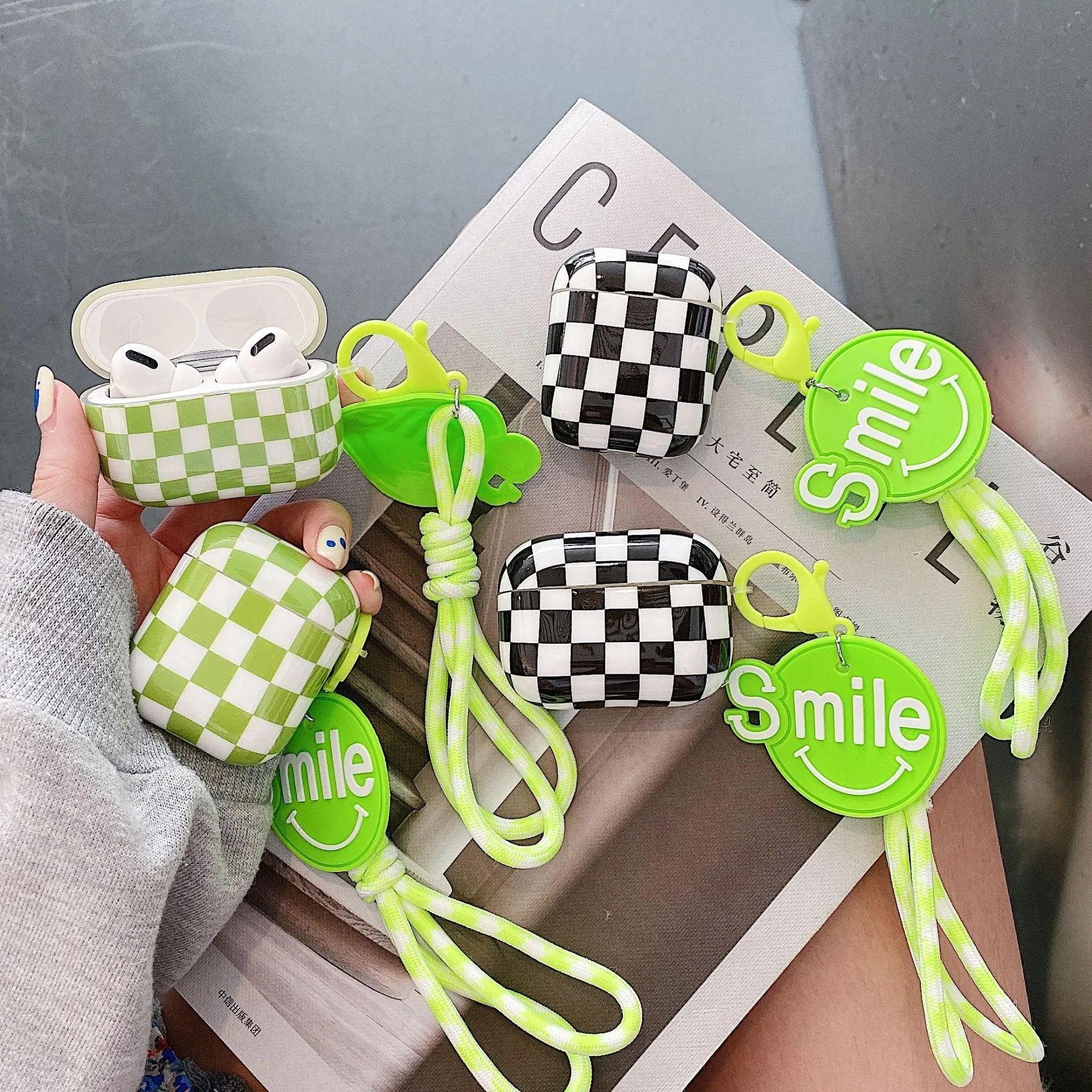 Black and green checkerboard pattern TPU protective case for Apple AirPods with optional smiley face lanyard.