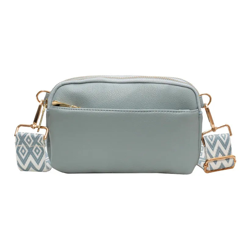 Women's cross-body bag in black, urban simplicity style, with visible sewing thread and sandwich pocket on front.