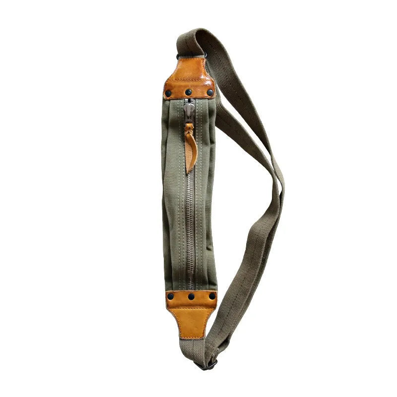Green military style chest bag made from canvas with leather accents and adjustable shoulder straps