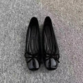 Pair of black patent leather Mary Jane flats with low heel and round toe