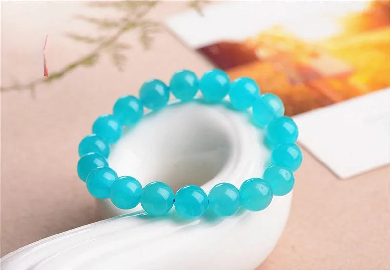 Polished natural Amazonite scattered beads in blue-green tones, shown loose and on a bracelet cord.