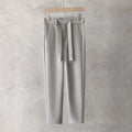 Boys slim straight wool trousers in tapered fit, shown in black, on a hanger.